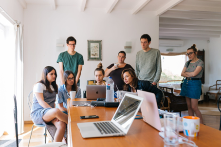 Several Coworkers looking on the screen of one laptop